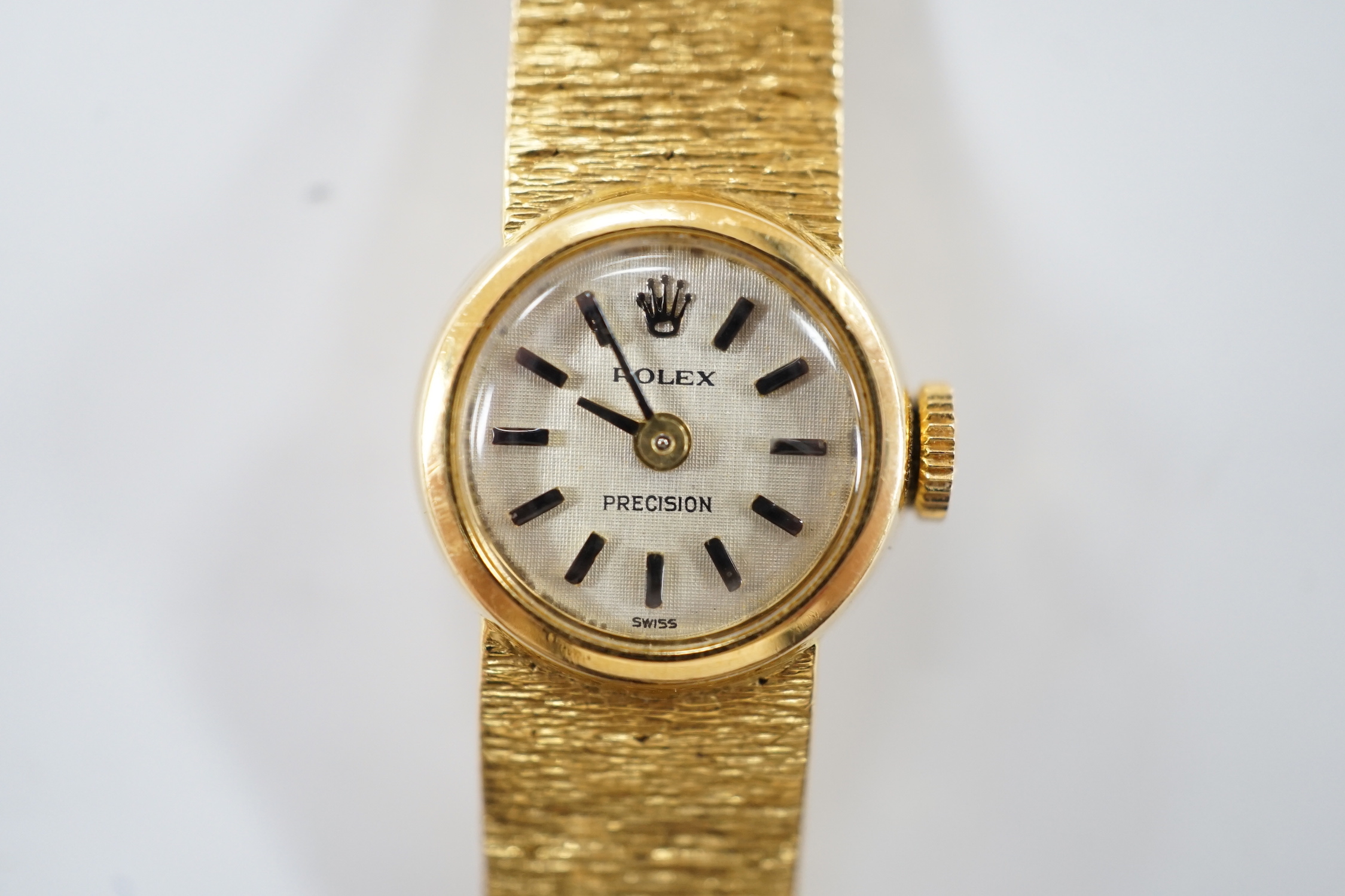 A lady's textured 750 yellow metal Rolex manual wind wrist watch, on integral bracelet, no box or papers, case diameter 15mm